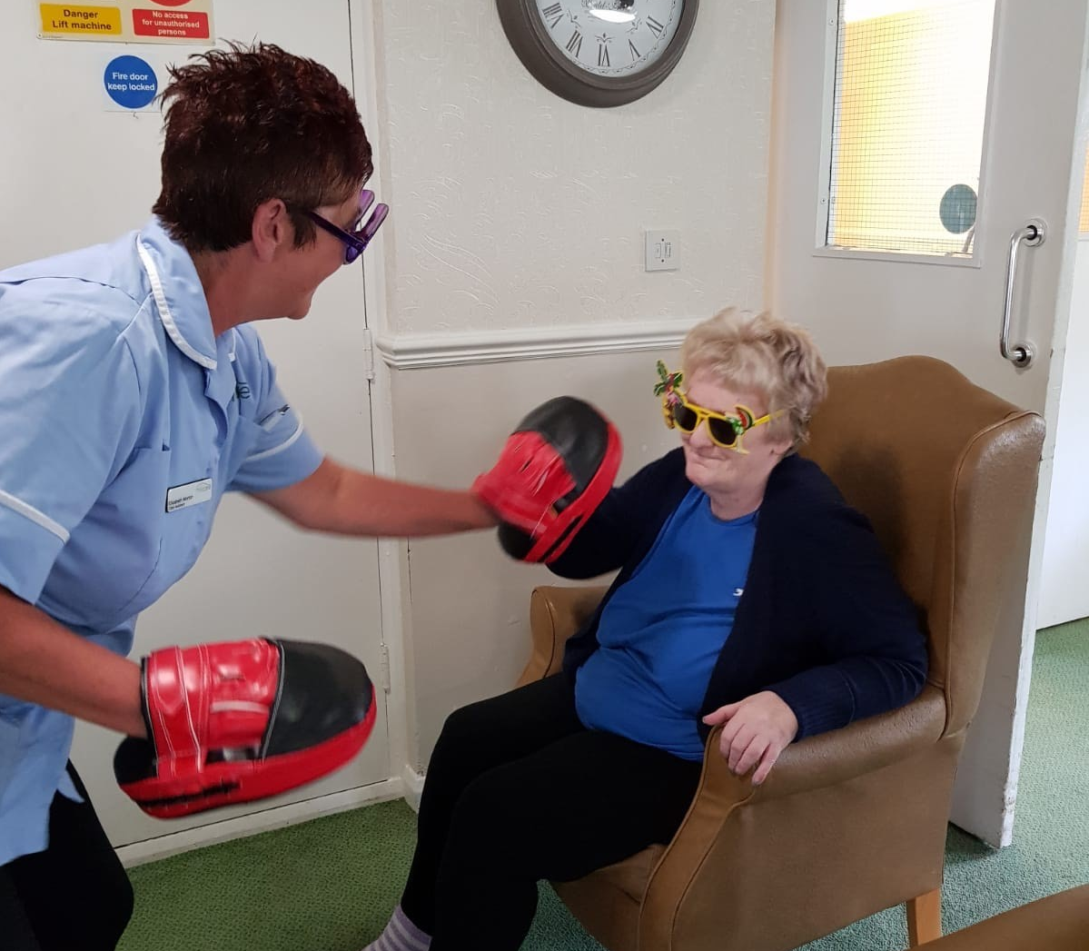 The Oaks Care Home resident Ann Lillico testing her punching power on pads held by carer Elizabeth Morton